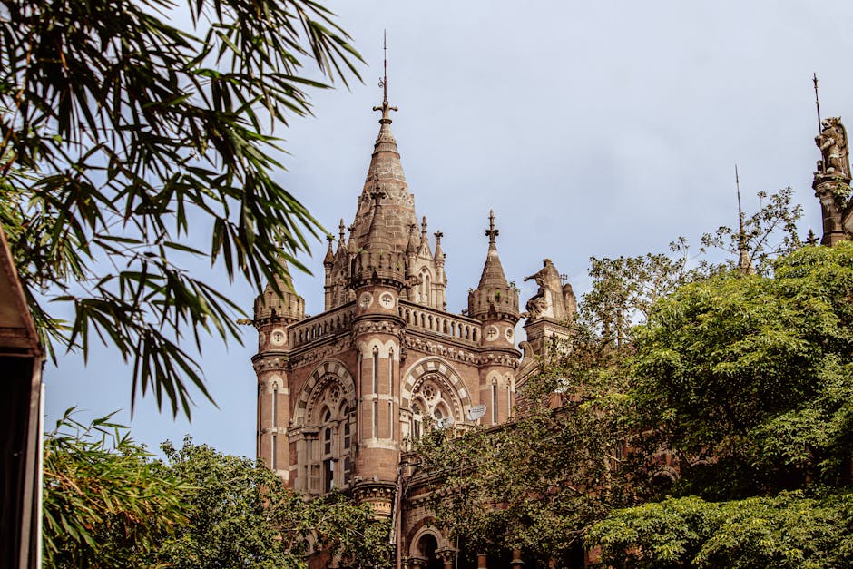 Stunning Victorian Gothic structure amidst lush greenery in Mumbai, India.